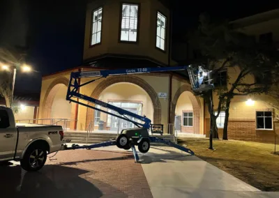 A truck is parked in front of a building at night.